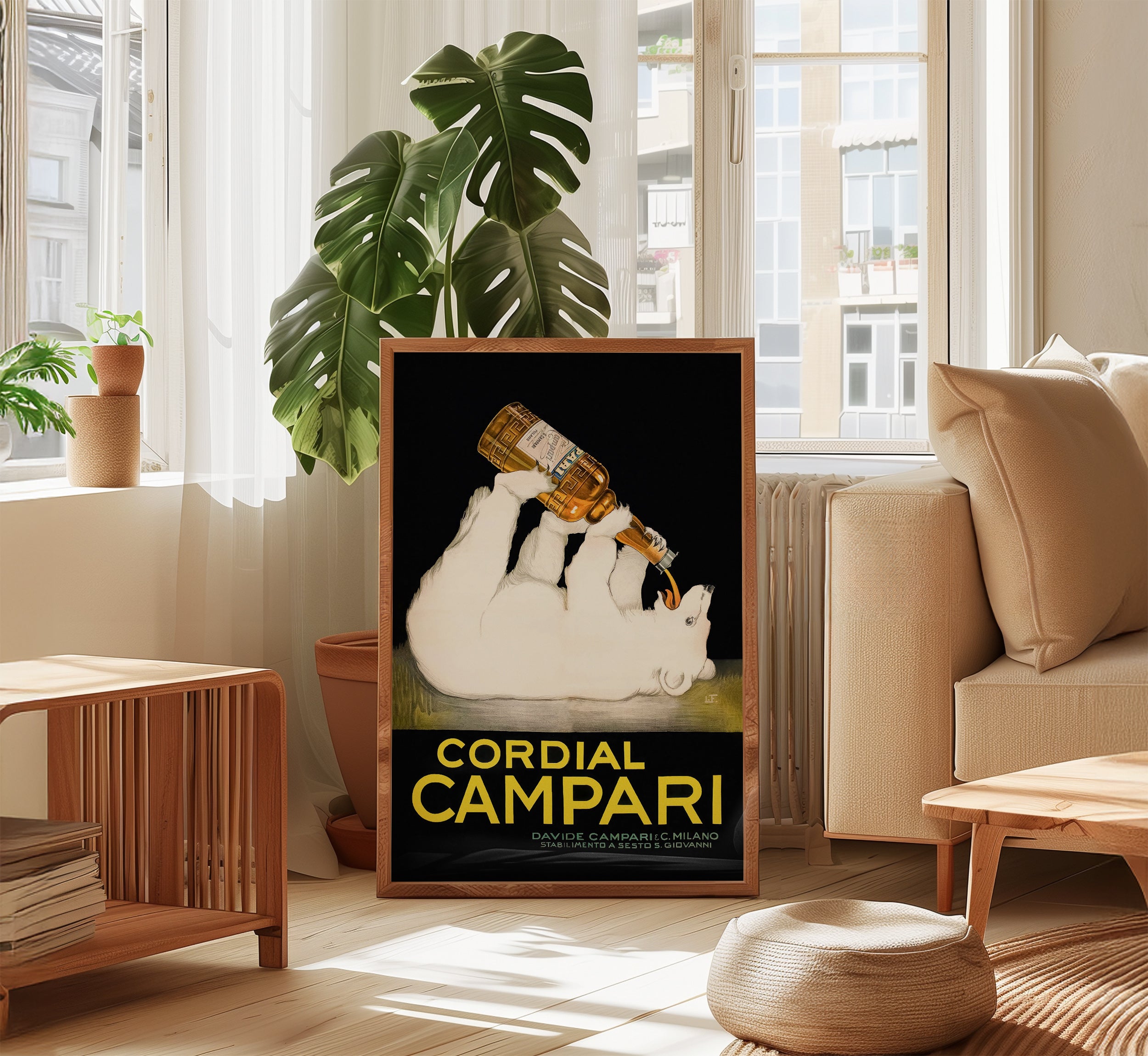 Framed Cordial Campari poster by Franz Laskoff displayed in a bright contemporary living room with natural wood furniture and large green plants.