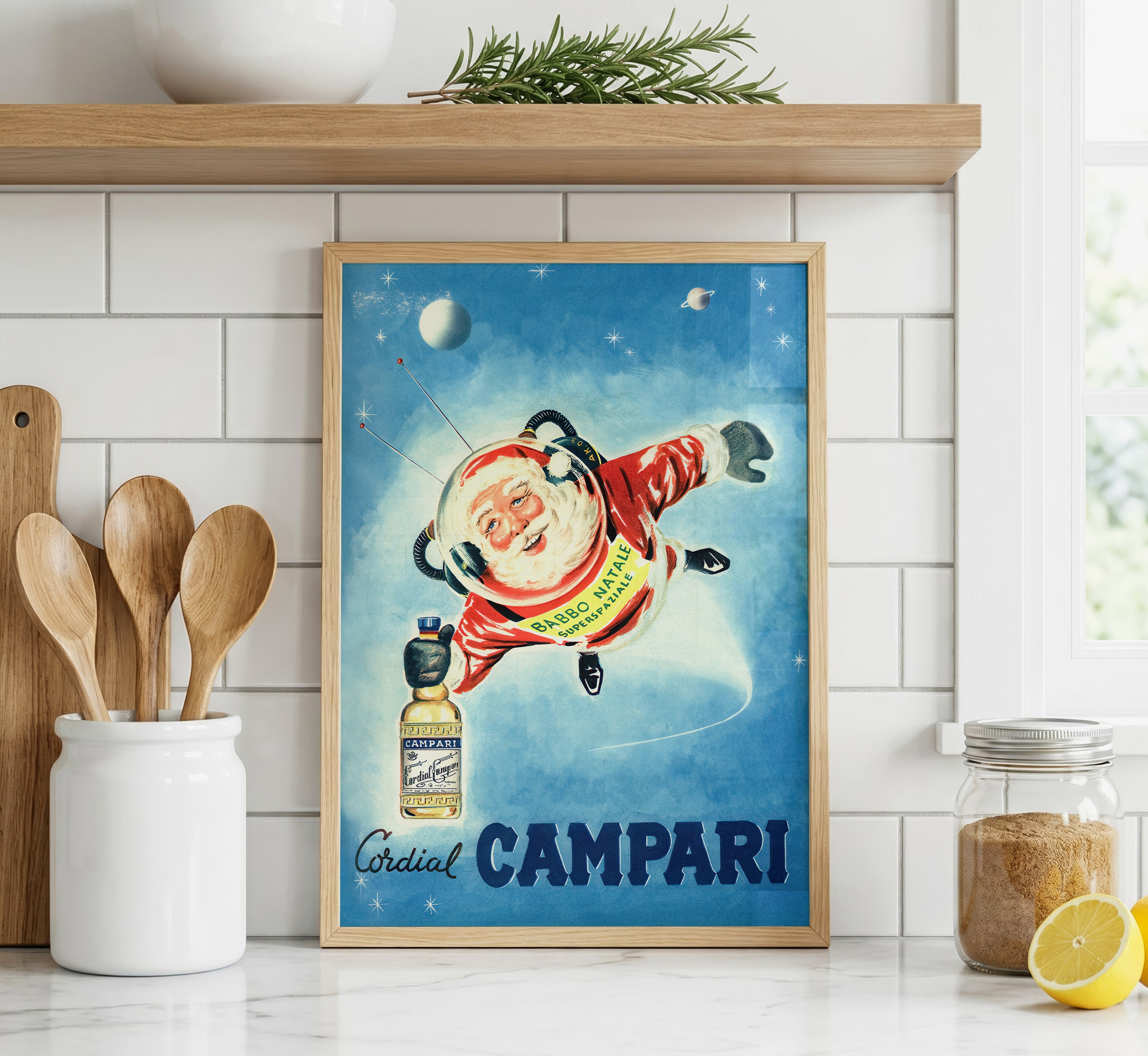 Cordial Campari vintage Christmas advertising poster featuring astronaut Santa displayed in a bright modern kitchen.