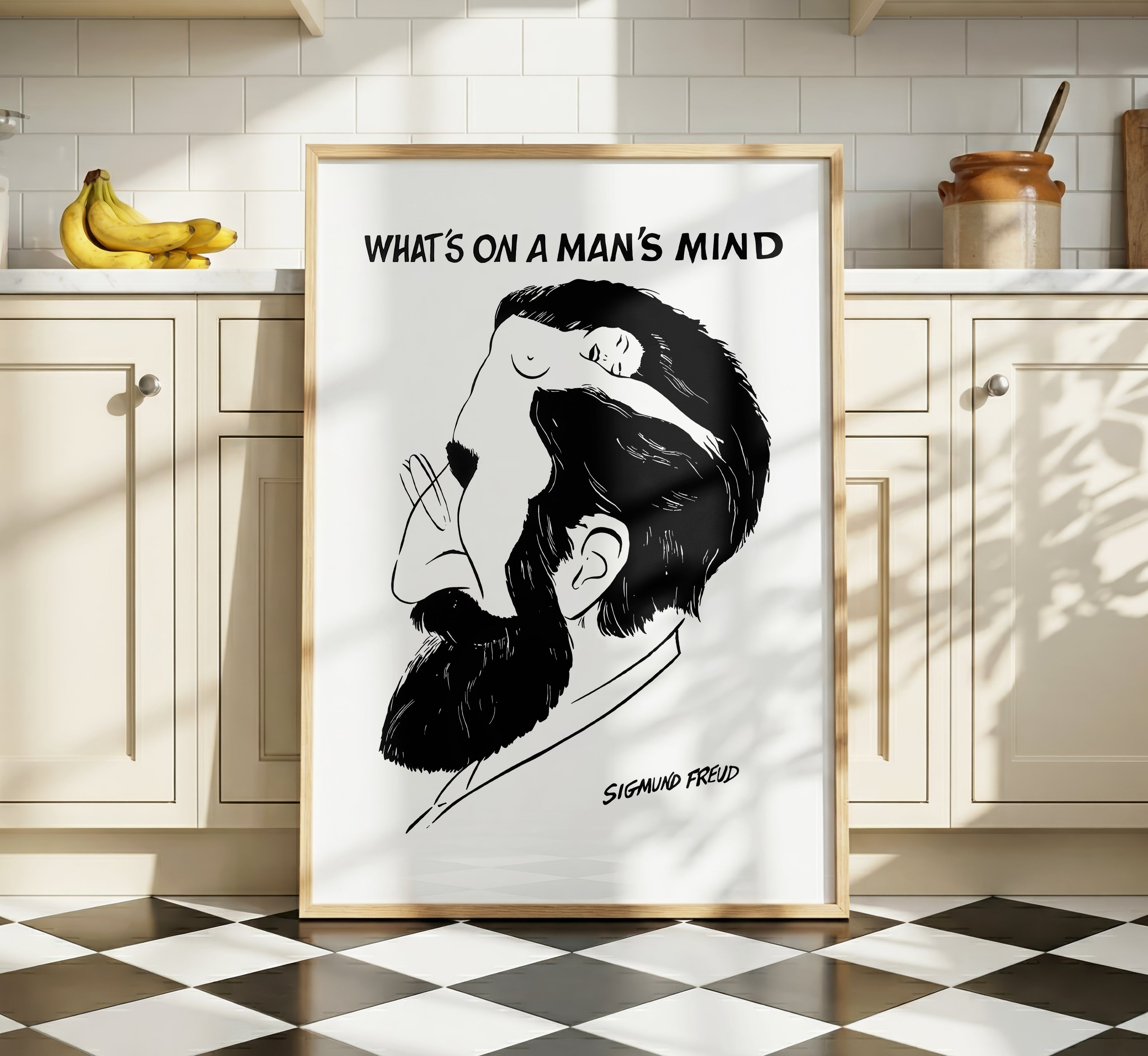 What’s on a Man’s Mind Freud poster displayed in a bright kitchen interior, featuring a black-and-white optical illusion portrait.